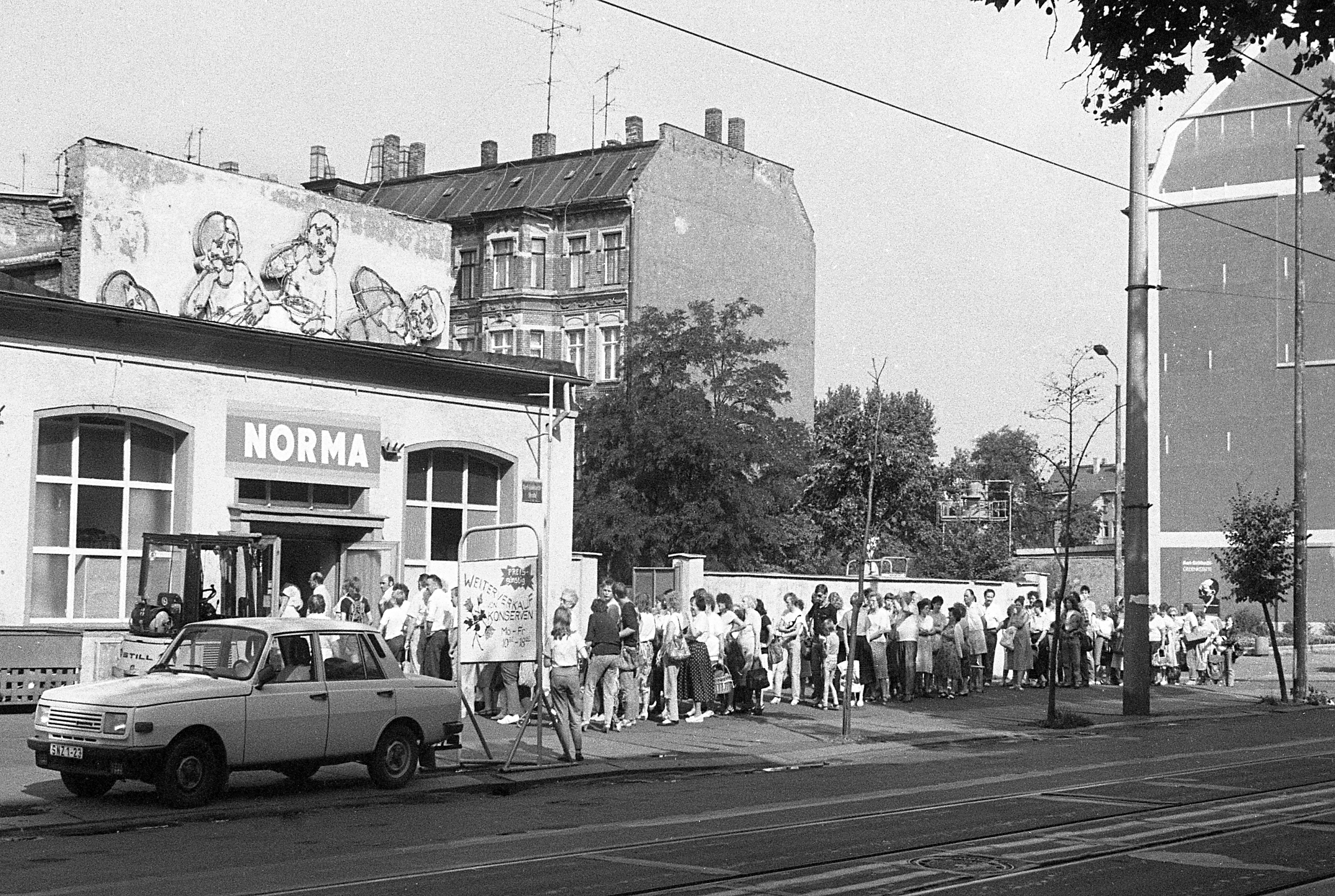 Straßenszene: Menschen stehen vor der Norma Schlange